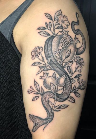 Illustrative tattoo by Amandine Canata featuring a snake intertwined with a pomegranate fruit in intricate dotwork style.