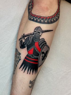 Embrace your inner knight with this traditional style tattoo featuring a sword, shield, and armor by Jakob Isaac.