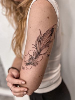 Get a stunning illustrative koi fish tattoo by the talented artist Alex Caldeira. The design is elegant and dainty, perfect for those looking for a unique piece of body art.