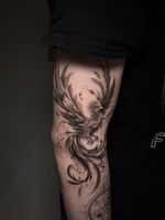 Black and grey phoenix tattoo symbolising rebirth, transformation and resilience. Designed with flowing feathers and dynamic movement.