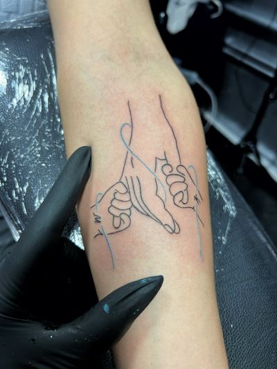 Fine line illustrative tattoo of hands connected by thread, symbolizing the bond of family, by artist Inna.