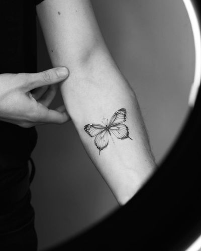 Get a delicate and detailed butterfly tattoo in fine line illustrative style by the talented artist Victoria.