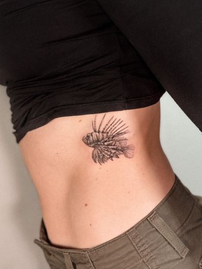 Experience the intricate beauty of a black and gray lionfish tattooed with precision by the talented artist Alex Caldeira.