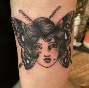 Discover the beauty of an illustrative traditional style tattoo featuring a graceful lady and a stunning butterfly, expertly crafted by Megan Foster.