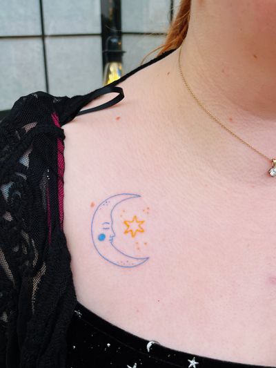 Fine line hand-poke moon and star tattoo by Laura, striking a balance between light and dark.