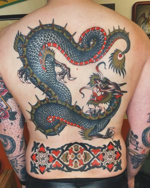 Get a fierce and striking traditional dragon tattoo designed by the talented Megan Foster. Let this mythical creature adorn your skin with its powerful presence.