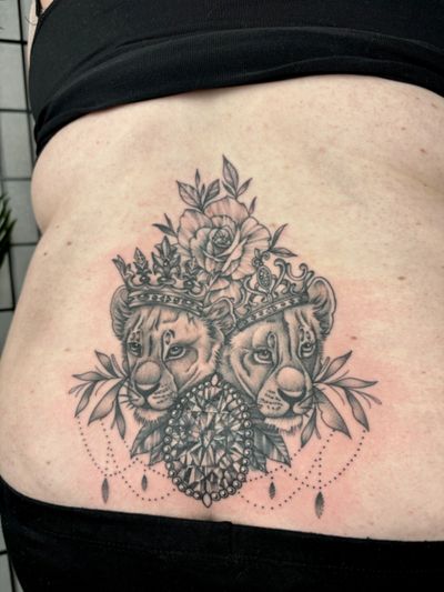 Elegant black and gray lion with intricate dotwork details and delicate flowers by Alice Hope Tattoo.