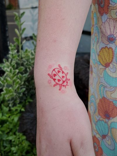 Illustrative and ignorant hand-poke tattoo of a ladybird by artist Laura.