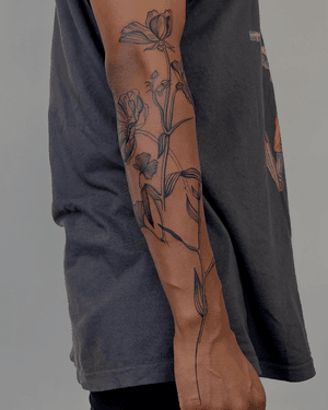 A stunning blackwork tattoo by Alona Hamova featuring intricate etched floral designs, perfect for botanical enthusiasts.