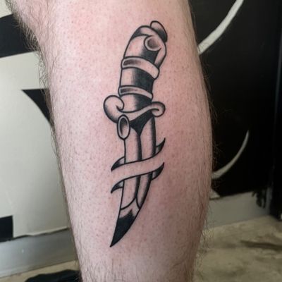 Get inked with a timeless traditional dagger design by the skilled artist Marc 'Cappi' Caplen. Bold lines and vibrant colors make this tattoo stand out.