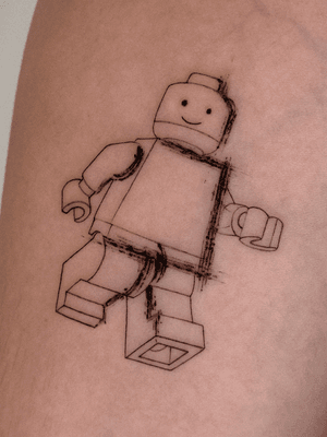 A unique blackwork tattoo by Alex Caldeira, combining lego and brush motifs in fine line illustrative style.