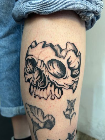 Jack Howard's blackwork, dotwork, illustrative tattoo features a detailed skull design with surreal elements.