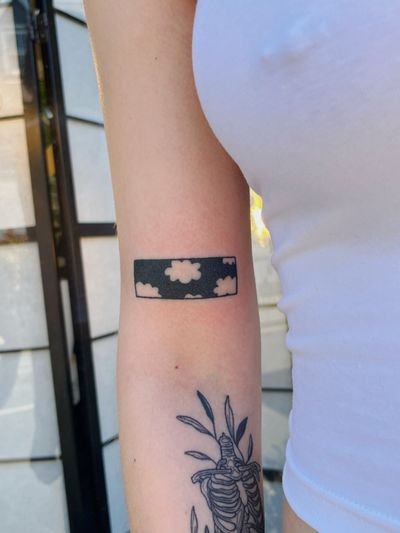 Blackwork and dotwork hand-poke tattoo by Laura featuring a serene sky with fluffy clouds in a panel design.