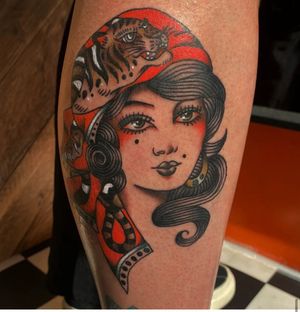Experience the mystique of a fierce tiger and elegant gypsy lady in this traditional illustrative tattoo by Megan Foster.