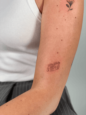 Fine line tattoo of a newspaper with good news by ᴢᴜᴢᴀɴɴᴀ, minimal and intricate design.