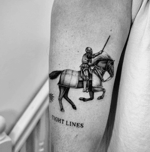 A stunning black and gray tattoo of a knight jousting on horseback, expertly depicted with micro realism by artist Georgina.