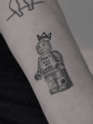 Abstract black and gray illustrative tattoo by Oliver Soames, combining lego, Basquiat, and a crown motif.