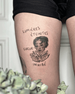 A conceptual surreal portrait tattoo in black and grey realism, featuring a pixelated female face with the phrase “Lumière éteintes cœur inhibé”. Executed in refined micro realism tattoo technique, this dreamlike composition explores emotional disconnection and identity distortion.