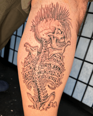 Get inked with this badass illustrative tattoo by Jonathan Glick, featuring a punk zombie skeleton motif.