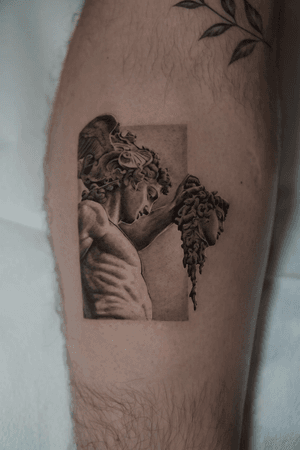 Detailed black and gray tattoo of Medusa and Perseus in Greek statue style by Kenny Go.