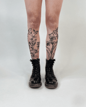 A blackwork etching tattoo by Alona Hamova featuring fine line floral motifs, creating a botanical garden design.