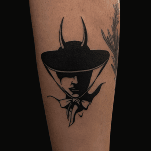 Blackwork tattoo by Connor Howerton featuring a mysterious lady with devilish elements and a shady demeanor.