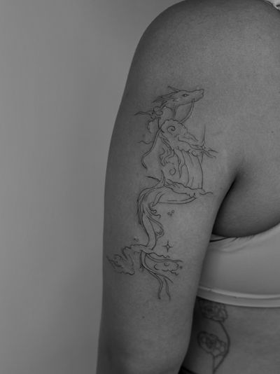 A fine line anime tattoo of a mystical dragon inspired by Studio Ghibli, created by Ruth Hall.