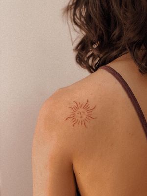 Get a unique sun tattoo in brown ink, hand-poked by the talented artist Anna. Choose a minimalist fine line design for a subtle and stylish look.