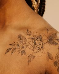 Delicate cherry blossoms and peony flowers in black and grey, made with the freehand method, flowing seamlessly on the arm, shoulder and collar bone, made on the darker skin tone, floral gap filler
