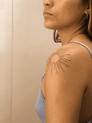 Embrace the essence of the sun with this delicate fine line design by tattoo artist Anna.