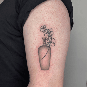 Abstract blackwork and dotwork tattoo featuring a unique and intricate design of a flower in a vase, created by artist Charlie Macarthur.