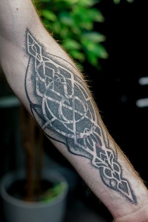 Experience the mesmerizing fusion of patterns and dotwork in this blackwork ornamental tattoo by Mona Noir Tattoo.