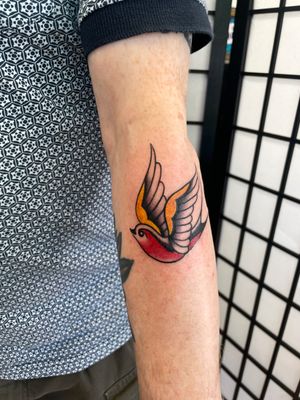 Get a classic traditional tattoo of a swallow bird by the talented artist Marc 'Cappi' Caplen. Timeless and bold design.