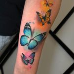 Beautiful butterfly design by Cloto.tattoos combining realism and watercolor styles for a stunning and vibrant look.