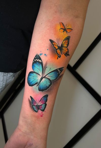 Beautiful butterfly design by Cloto.tattoos combining realism and watercolor styles for a stunning and vibrant look.