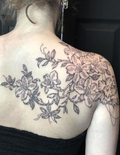 Capture nature's beauty with this floral and illustrative tattoo featuring a tree branch and flowers, expertly done by Amandine Canata.