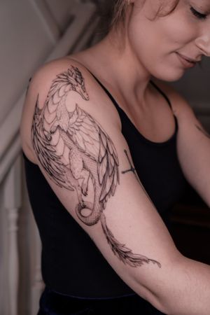 Elegant black and gray dragon tattoo, meticulously crafted by Maria. Surreal and mesmerizing.