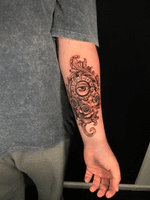 Black and grey eye tattoo with filigree and a clock