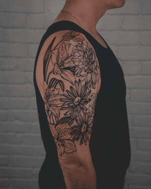 A striking blackwork tattoo by Alona Hamova, featuring an intricate etched floral design inspired by botanical elements.