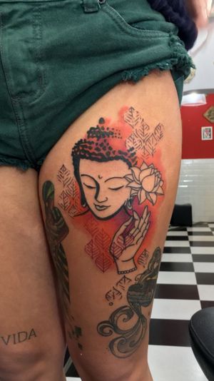 Vibrant watercolor design by Sandro Secchin, featuring a peaceful Buddha surrounded by delicate flowers on the upper leg.