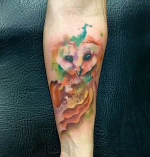 Get a stunning watercolor owl tattoo on your forearm by talented artist Sandro Secchin. Vibrant colors and intricate details!