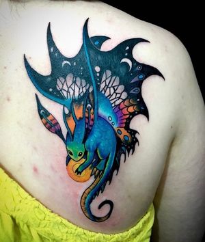 Get a stunning new school dragon tattoo on your upper back by the talented artist Sandro Secchin.