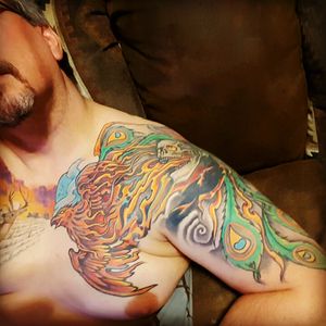 Chest to half sleeve, Phoenix through an awesome skull. Done by Ernie Serv 1 from Top Rocker.