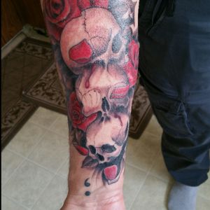 Three skulls....surrounded by roses...rose petals placed to visually represent hear no evil, see no evil, speak no evil