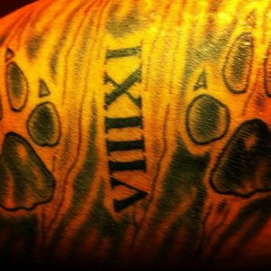 This piece was a concept that I drew up personally and had tattooed on my inner bicep. The roman numerals represent my mother's birthday and the paw prints represent her love for animals.