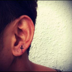 Cool minimalist cross earlobe tattoo