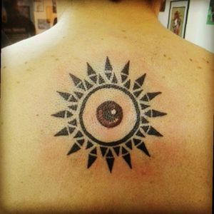 1st Tattoo - Tribal sun with red eye on my upper back
