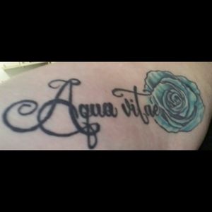 "Water of life" in Latin. Dedication to whiskey tattoo. #wateroflife #whiskey #teal #rose #script #bodyrevolution #willoughby #ohio #ohioink #innerarm