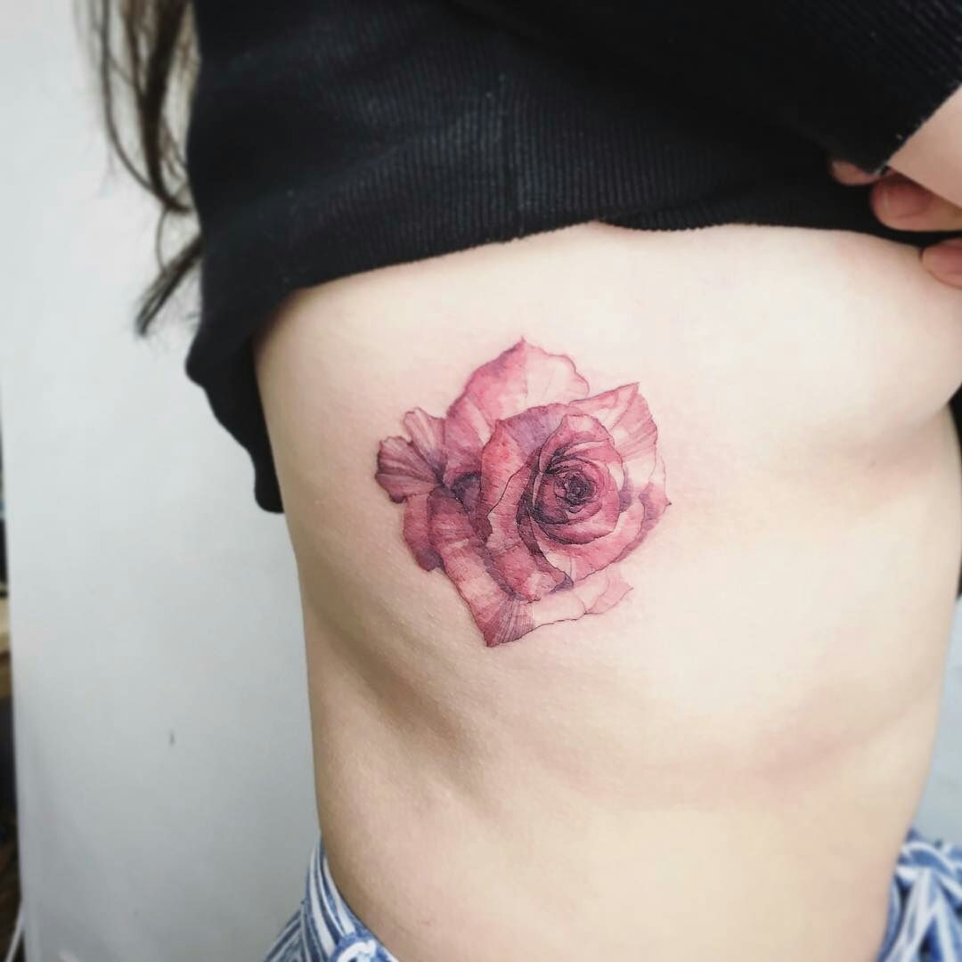 Fine line rose tattoo located on the rib