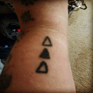 A tattoo me and my two sisters share. The triangle that's shaded is our order of birth.